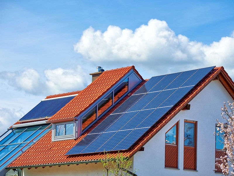 Das Bild zeigt ein modernes Haus mit Solarheizung und Photovoltaikanlage.